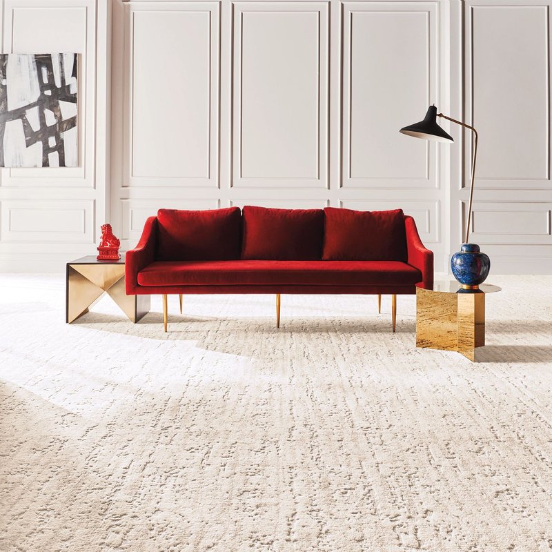 A red couch on a white carpet from Domenic and Sons Floor Covering in Johnston, RI